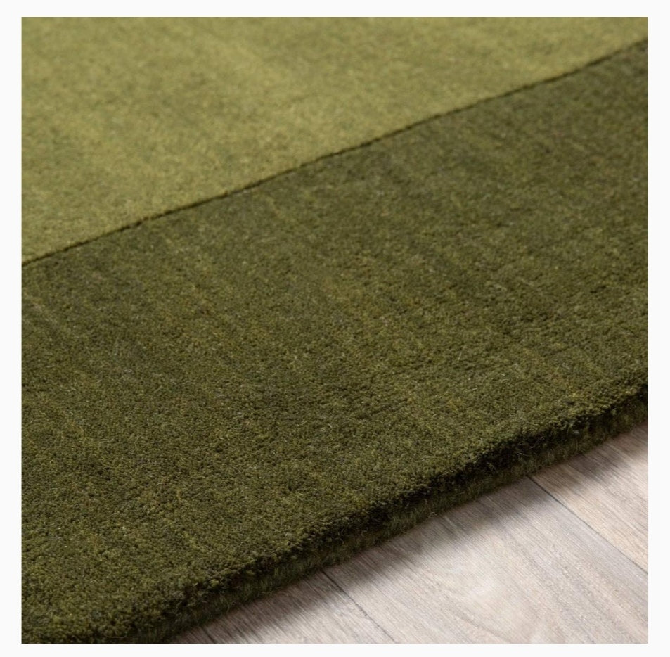 Green rug on a wooden floor