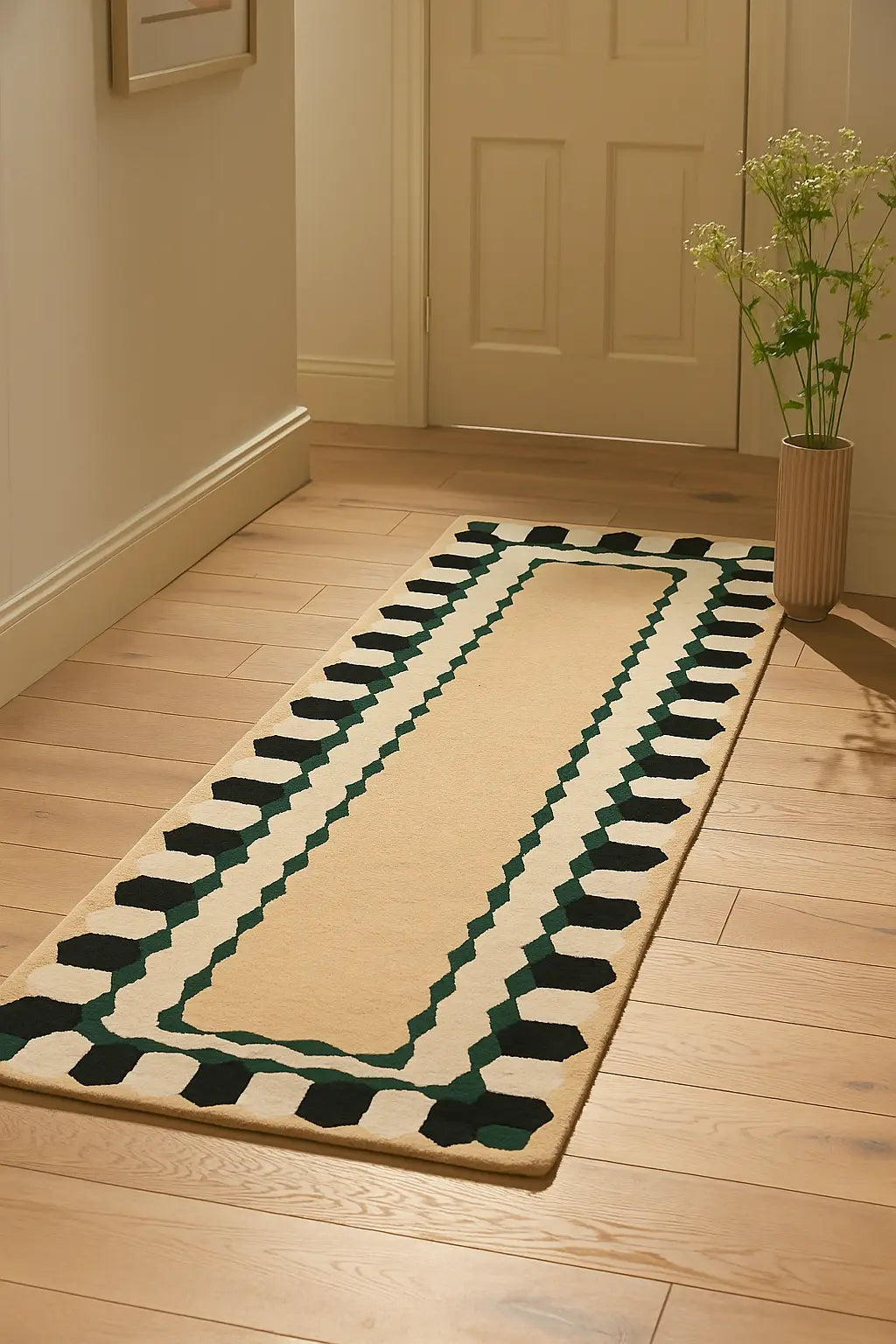 Hand-tufted beige wool runner rug with green geometric border in hallway