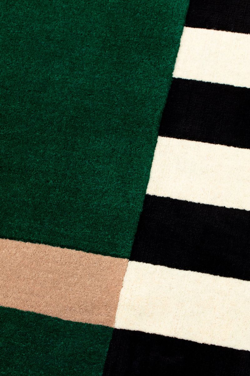 Close-up of a green fabric with a brown stripe and a black and white striped fabric.