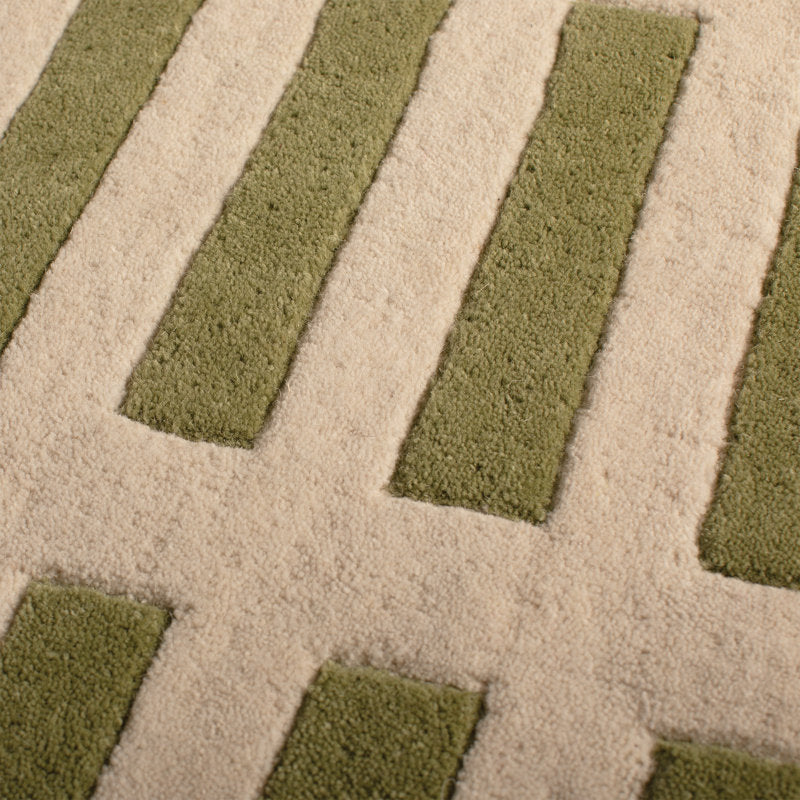 Close-up of a textured rug with green and beige pattern