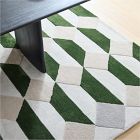 Green and white geometric patterned rug on a wooden floor