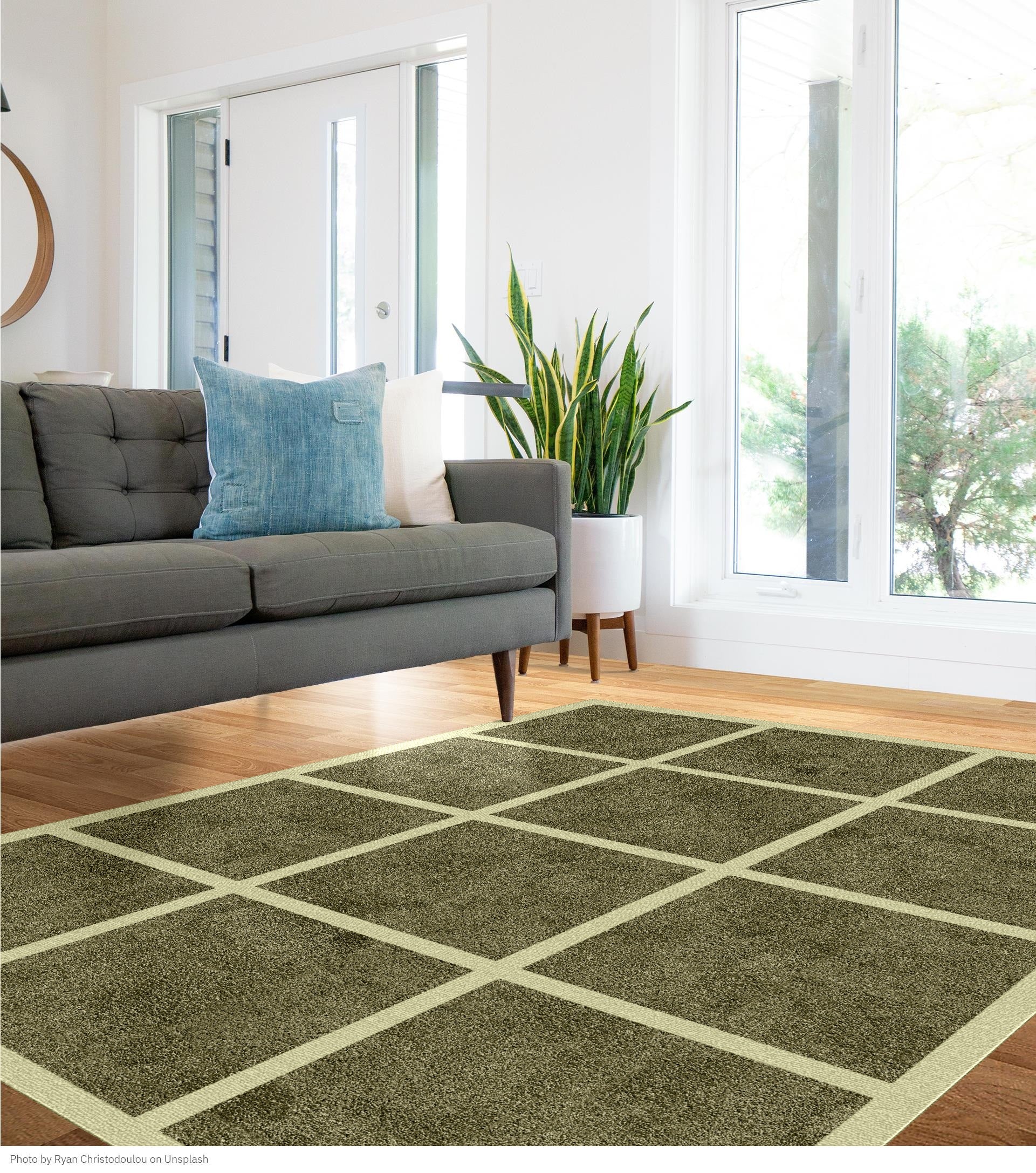 Living room with a green checkered hand-tufted rug, gray sofa, and large windows.