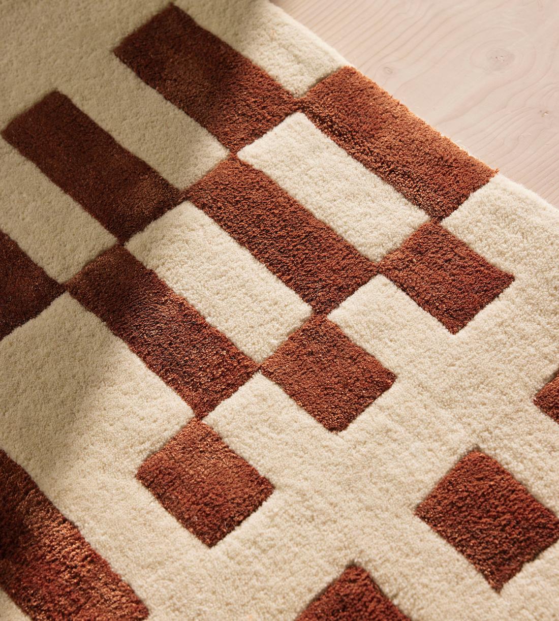 Close-up of a checkered pattern rug with brown and beige squares.