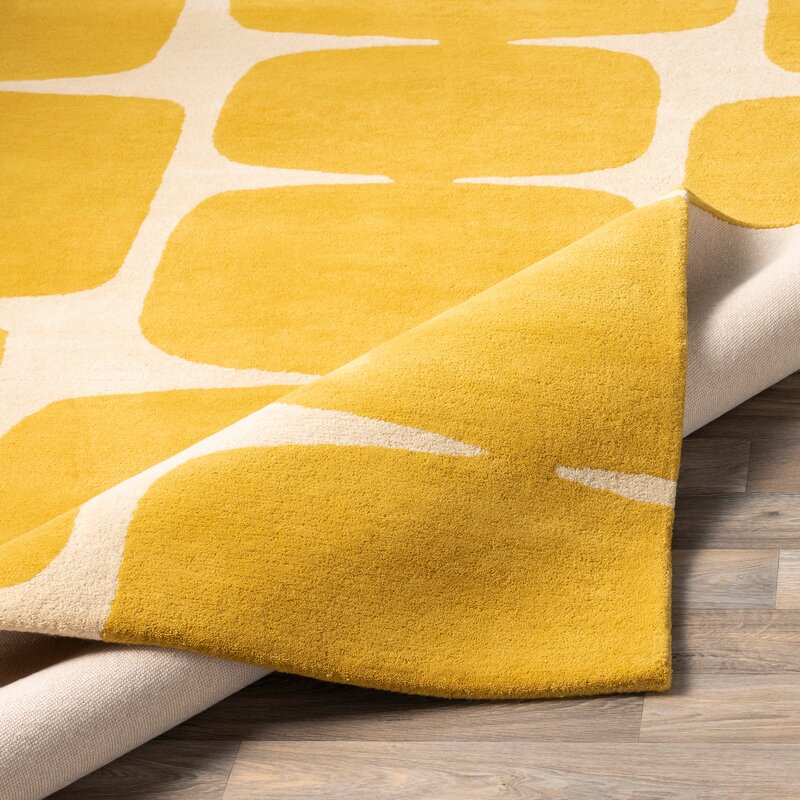 Yellow and beige patterned rug on a wooden floor