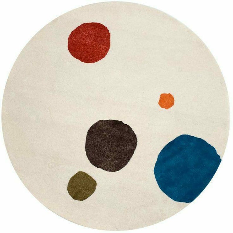 Ivory round hand tufted rug with scattered red blue olive brown and orange organic color blocks