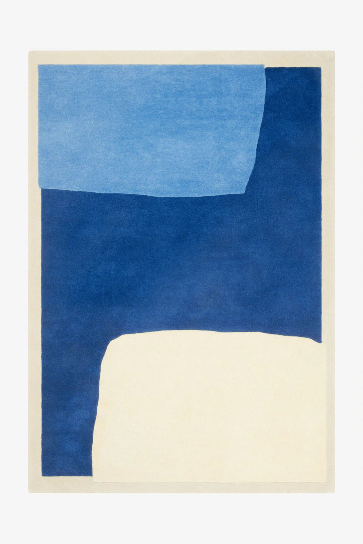 Rug with blue and beige color block design on a white background