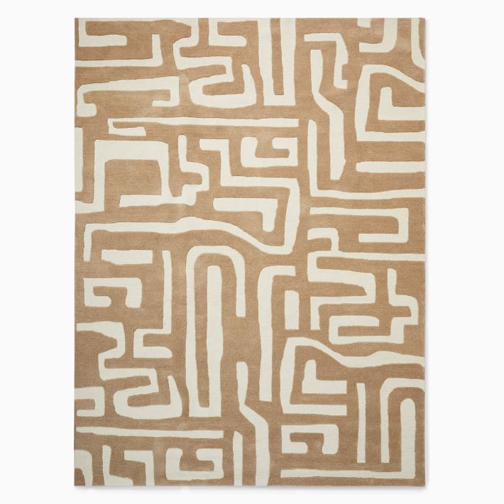 Hand-tufted rectangular wool rug featuring a beige and ivory abstract maze pattern in a modern living room.