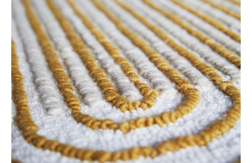 Close-up of a textured rug with yellow and white pattern