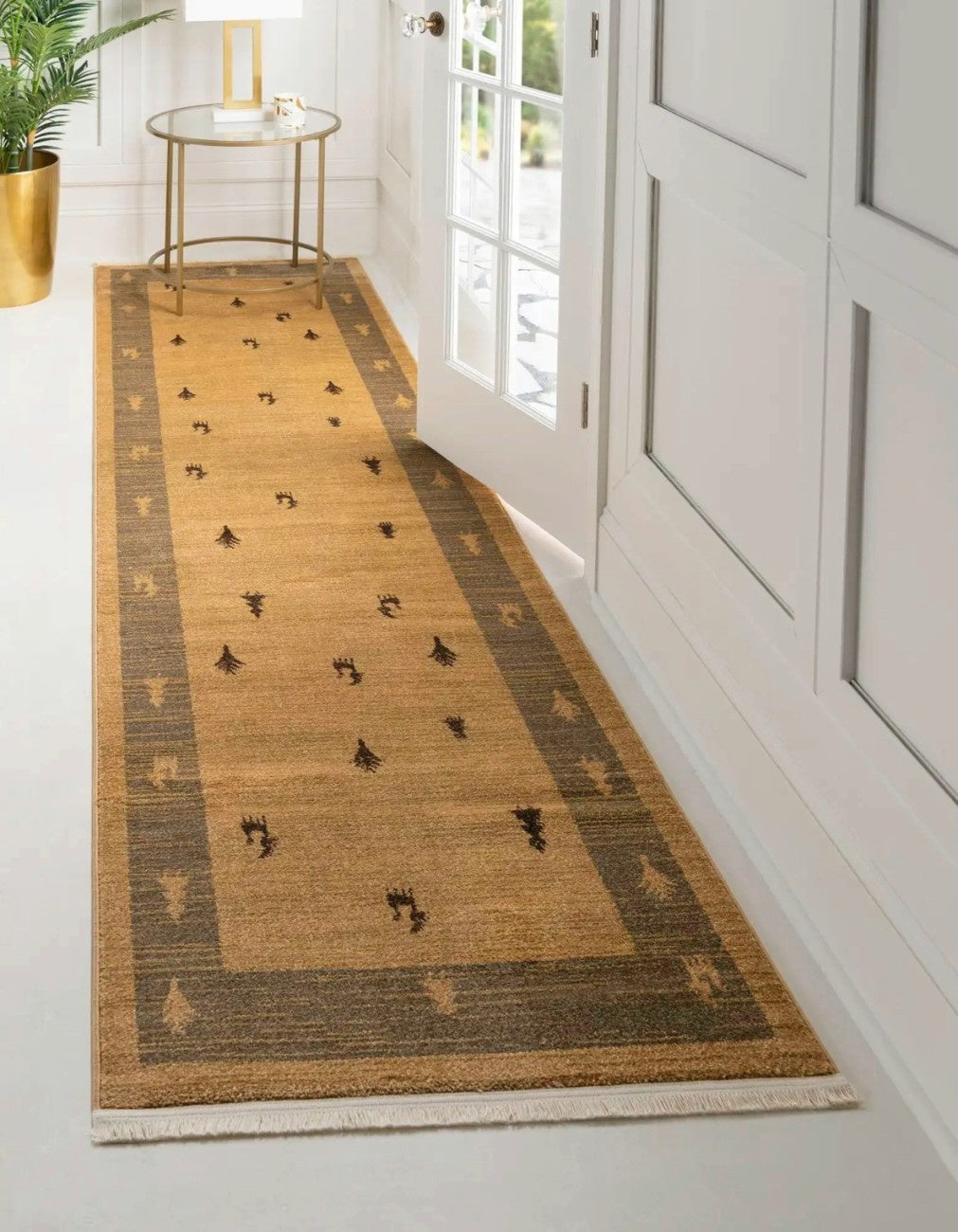 Hand-woven jute runner rug with charcoal border and tribal motifs in a white hallway.
