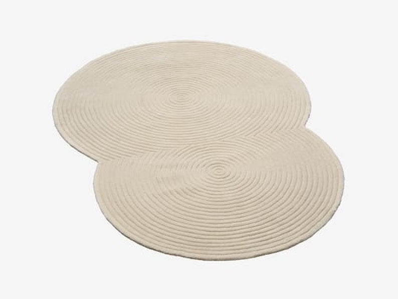 Two round beige braided placemats on a white background