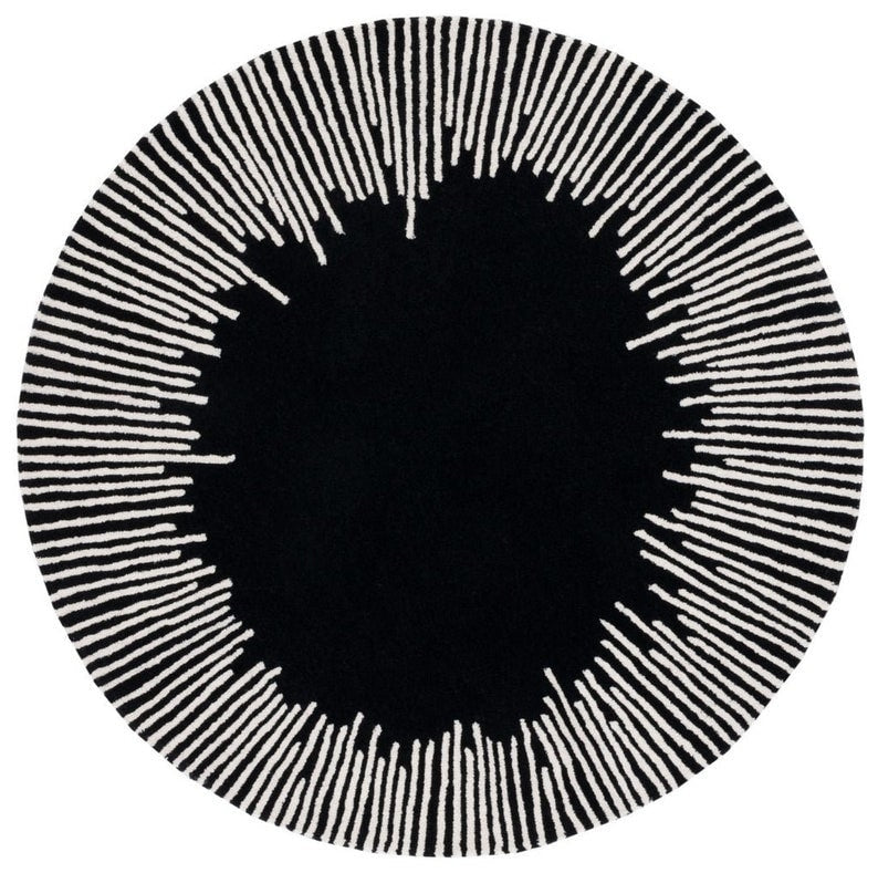 Top-down view of a circular black area rug featuring an ivory sunburst or radial stripe pattern with a solid black center.