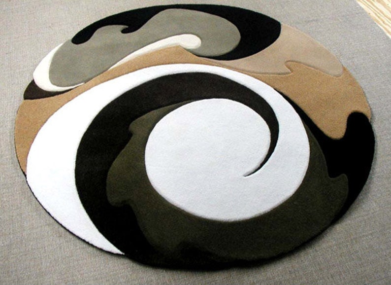 Round rug with abstract design in brown, black, white, and beige on a gray floor.