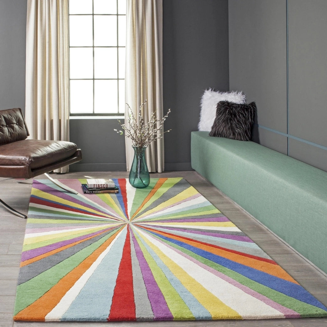 Modern hand-tufted wool rug featuring a colorful multi-color starburst pattern radiating from the center in a contemporary living room setting.