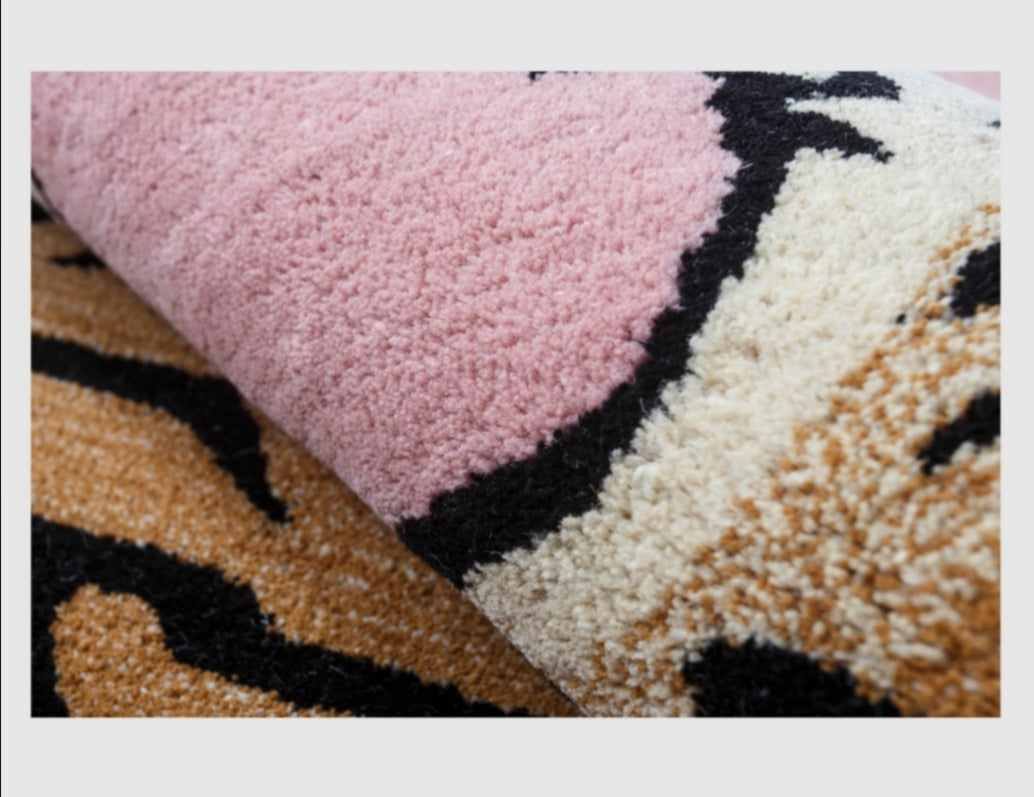 Close-up of a textured fabric with pink, black, and beige patterns.
