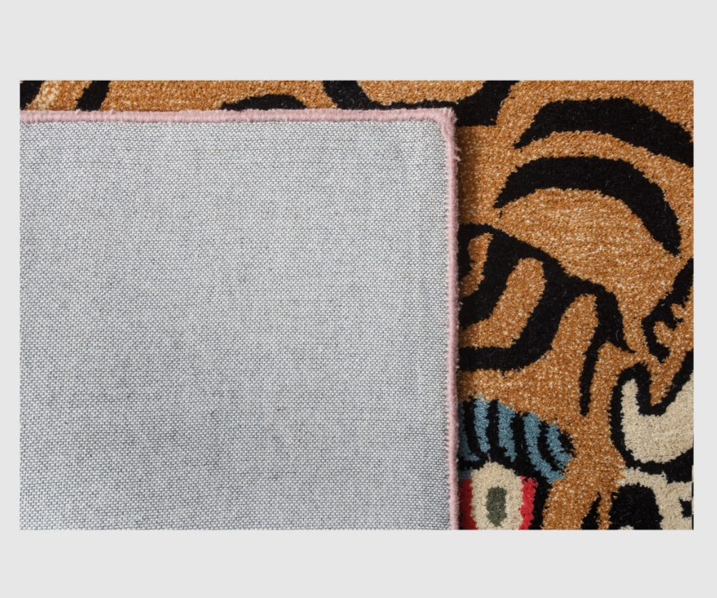 Close-up of a textured gray fabric sample next to a patterned fabric with animal designs on a light gray background.