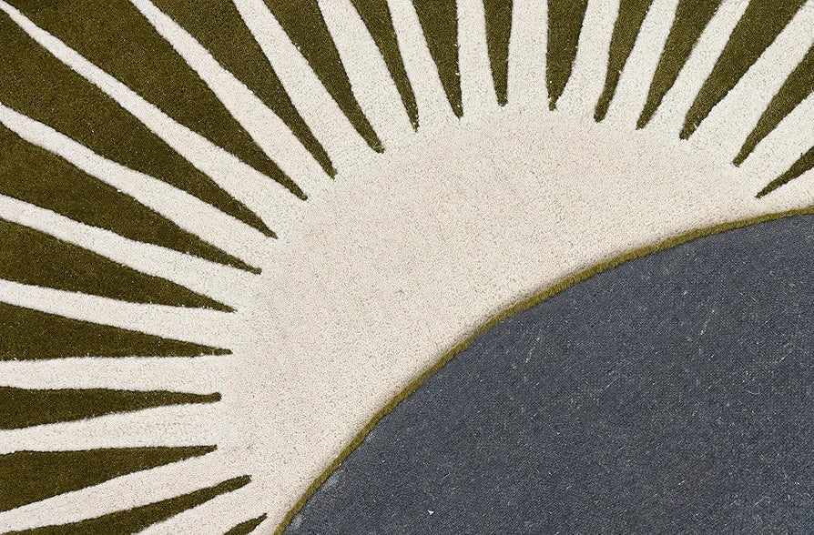 Close-up of a rug with a sunburst pattern in green, beige, and gray.