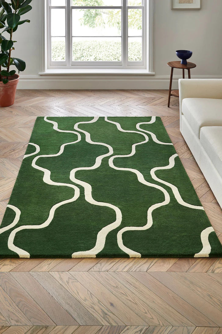 Hand-tufted green and cream wool rug with abstract curved wave pattern in a modern living room