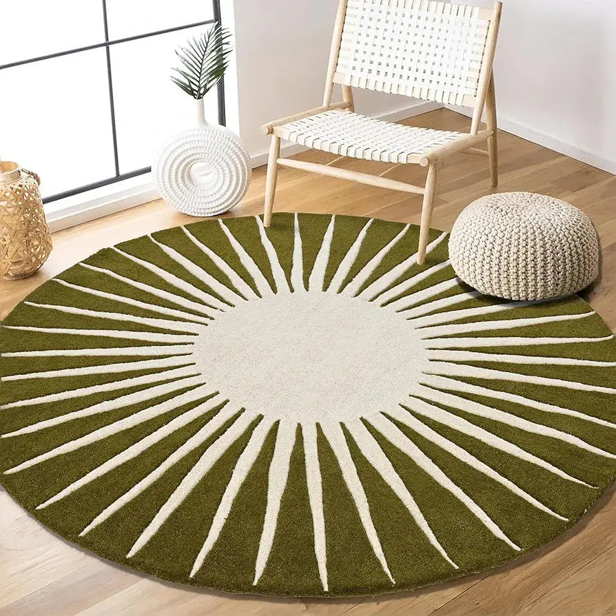 Round green hand tufted rug with white patterns on a wooden floor, chair, and pouf in the background.