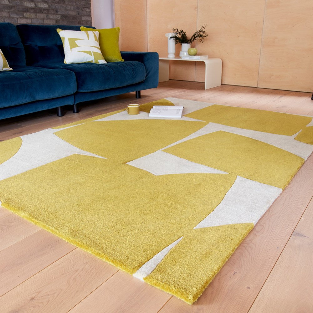 Mustard yellow and beige hand-tufted wool rug with a modern abstract pattern in a living room.