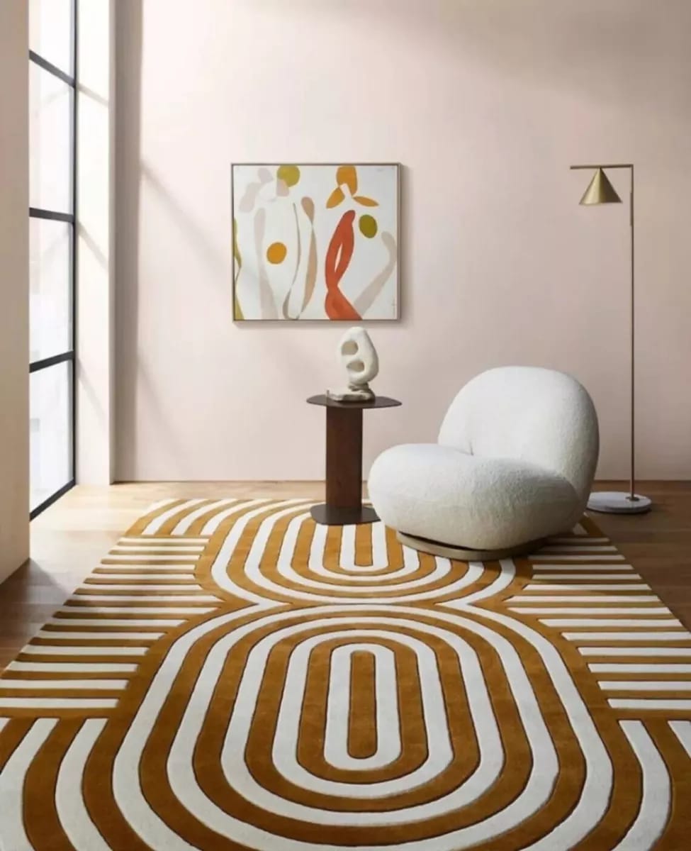 Brown and beige hand-tufted wool rug with a modern retro geometric pattern, styled with a small accent chair.