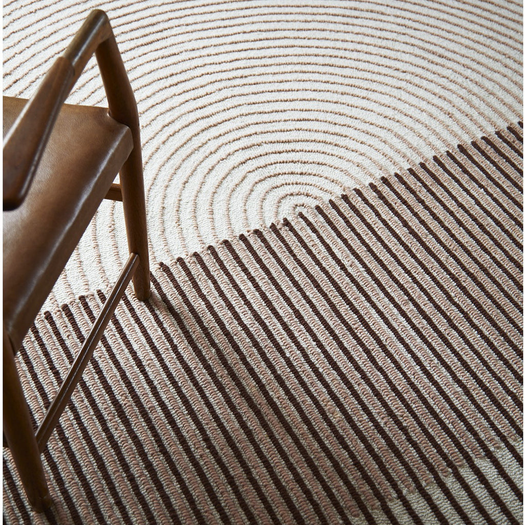 Close-up of a textured brown and beige rug with a chair corner.