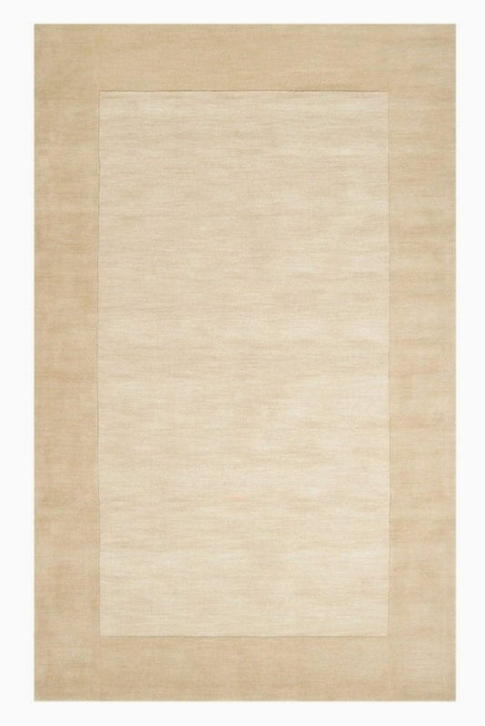 Beige area rug with a subtle pattern on a plain background
