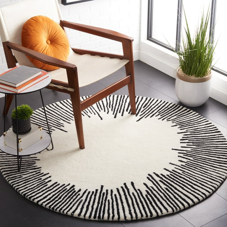 Round black and white striped rug in a room with a chair, books, and plants.